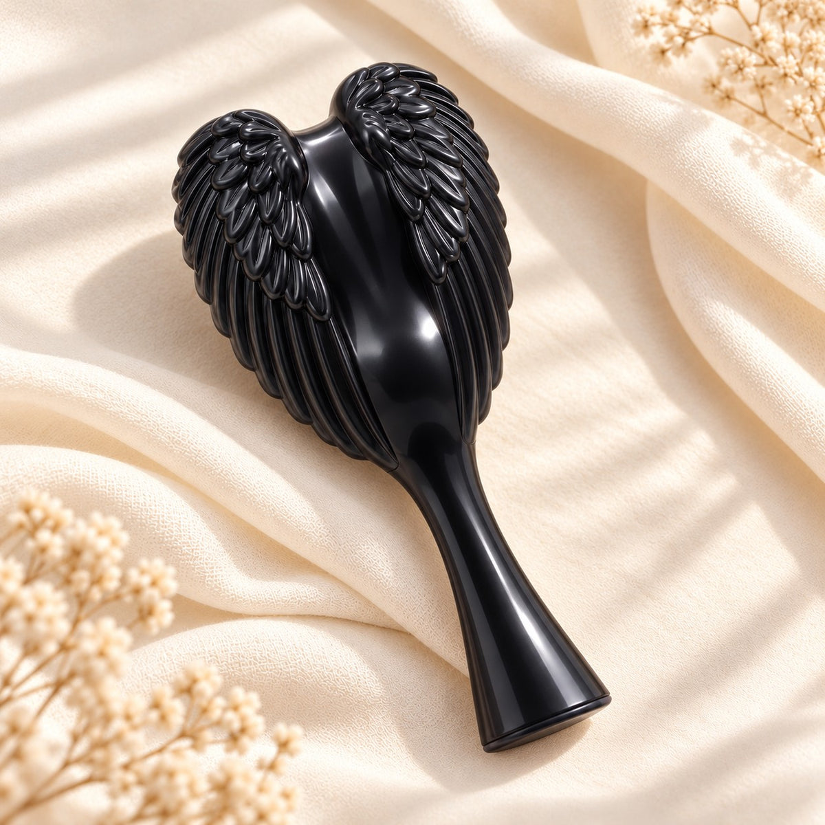 Black Angel Hairbrush with glossy sculpted angel wings on cream silk