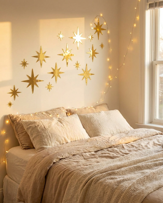 Gold mirror star stickers above a cosy bed
