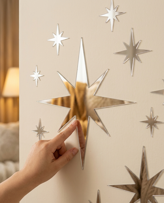 Silver mirror star sticker being placed on a wall